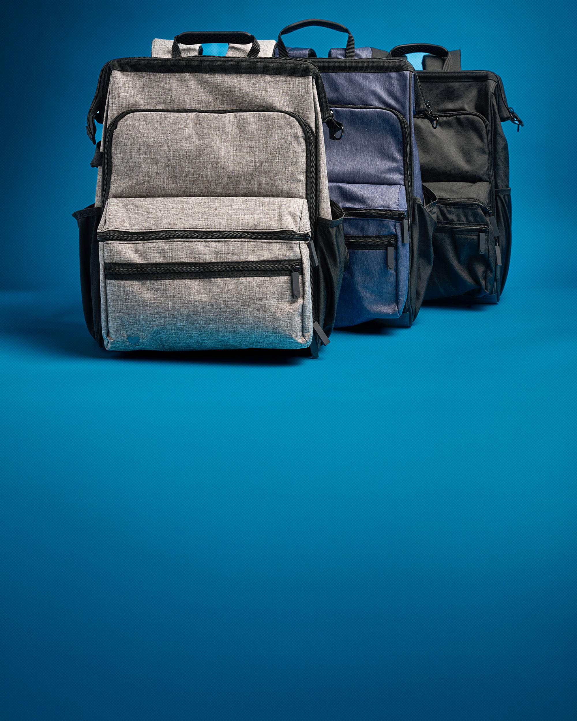 The Signature Backpack in all three colors, one behind the other.