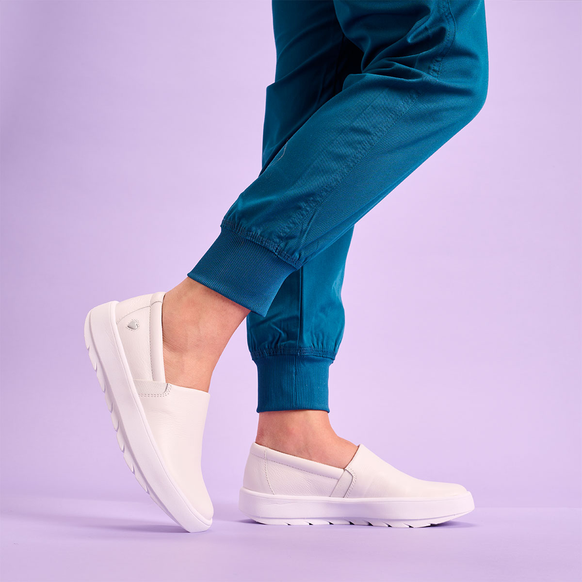 Woman wearing the Cascade slip on shoe in white on foot.